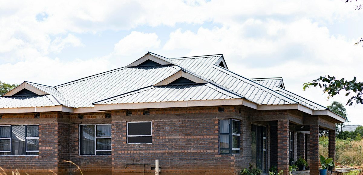A brick home with a silver standing-seam metal roof