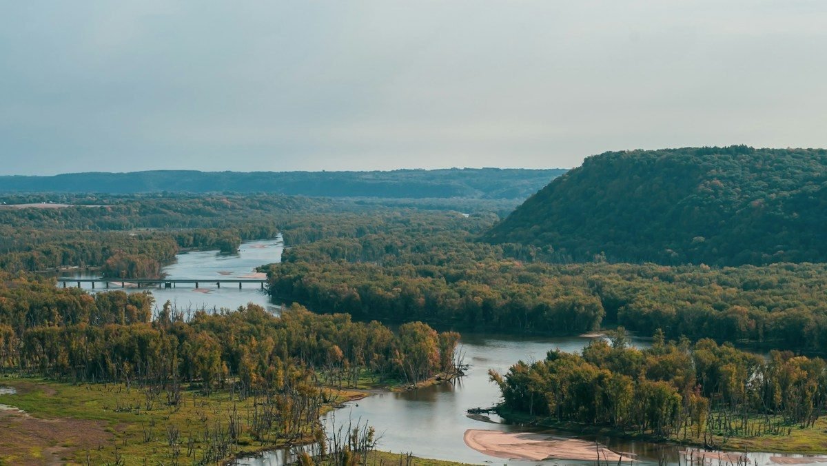 A river valley with wooded bluffs and wetlands