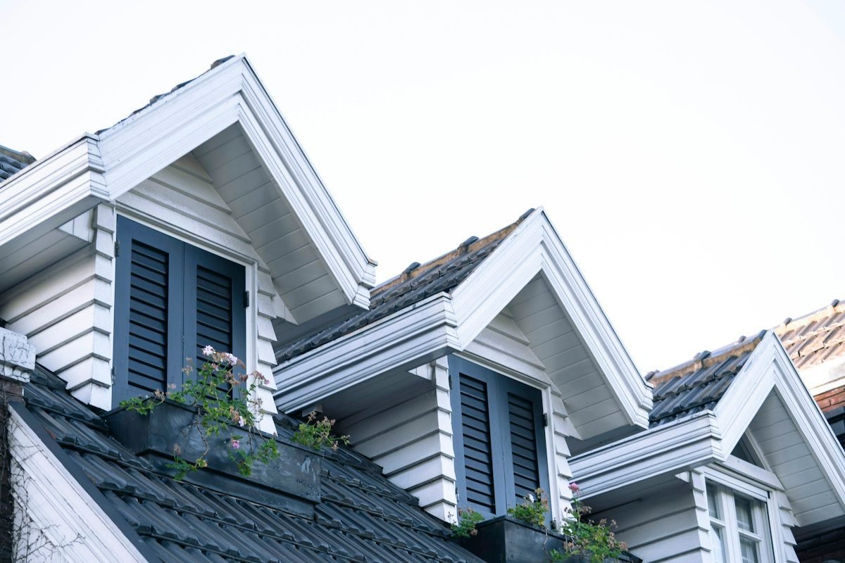 Dark shingle roof with three white gabled dormers