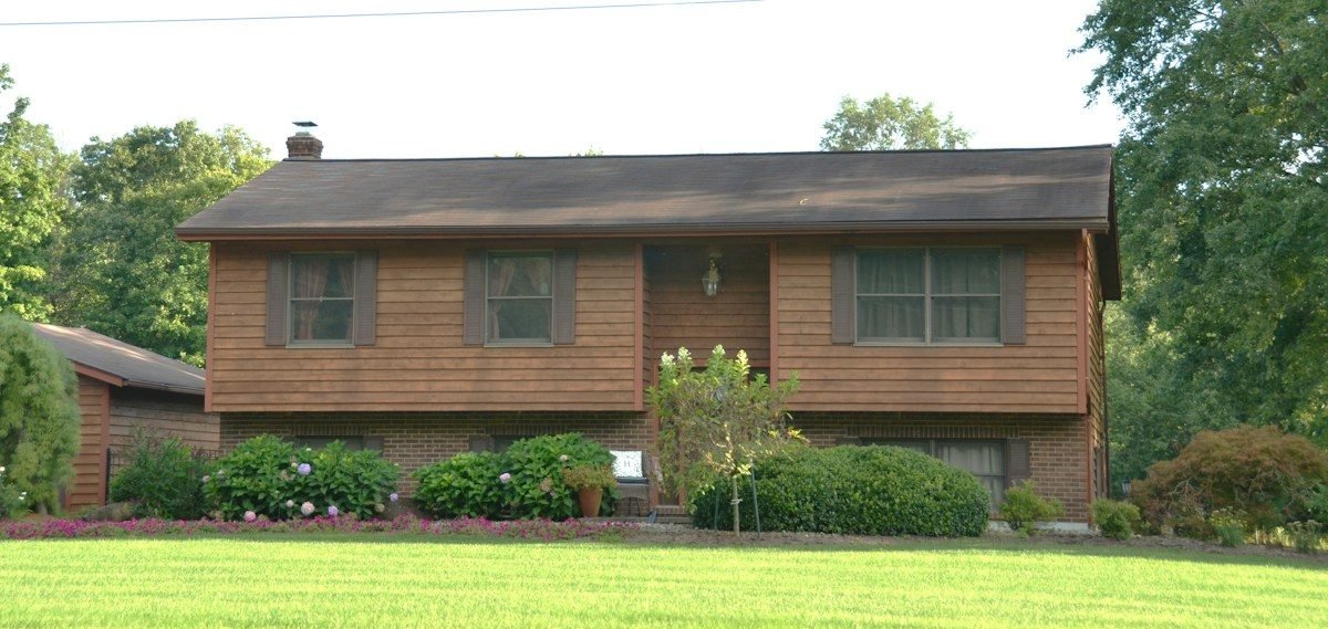 A split-level house with a brick lower floor and a shingle roof